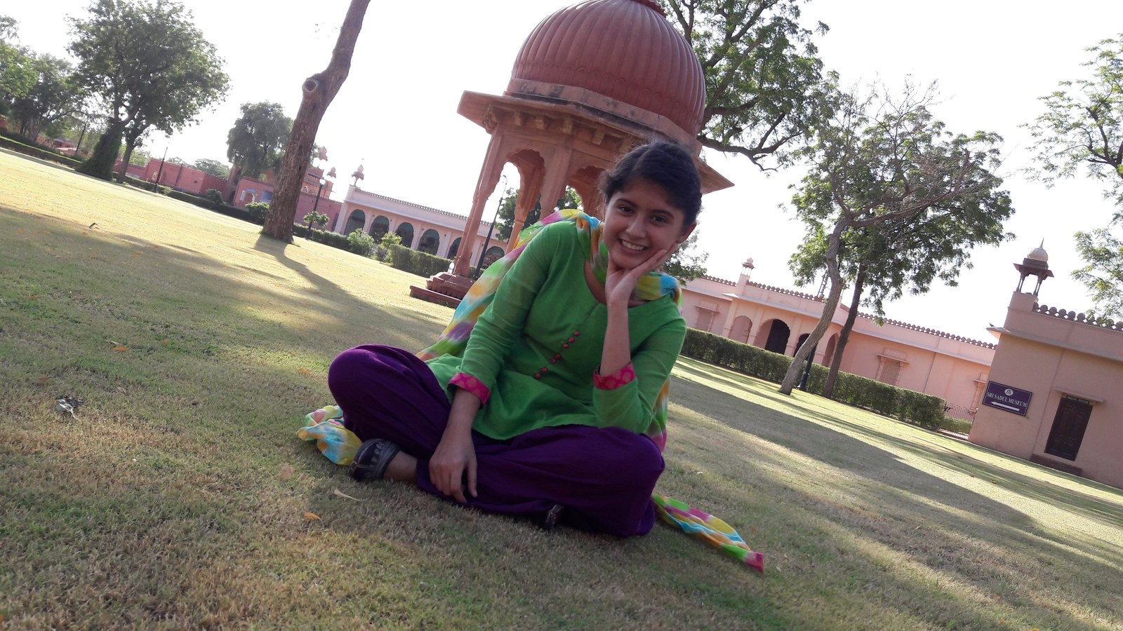 Arishfa Khan sitting outdoors in traditional attire, smiling warmly